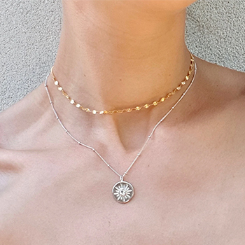 Золотые и серебряные цепочки на шее.