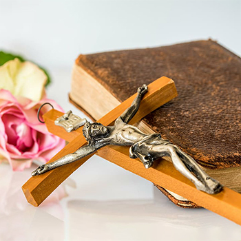 Крестик с распятием на библии и роза.